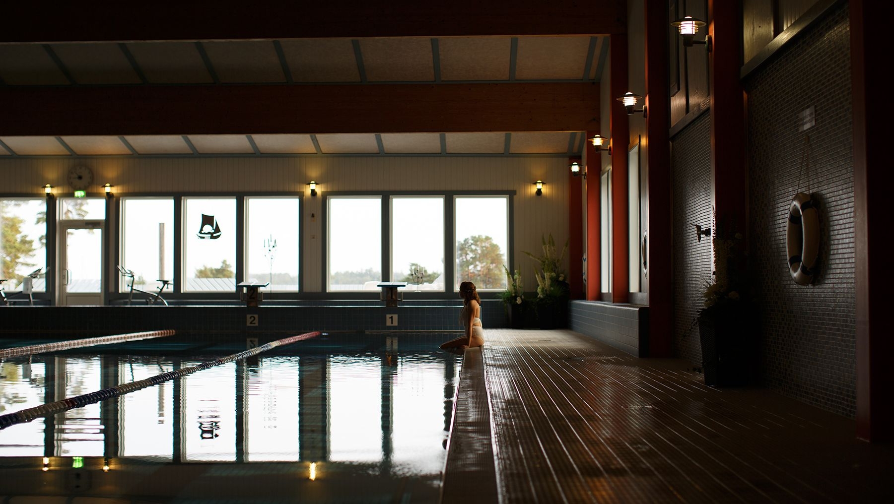 A guest sits beside the pool at Kasnäs Resort.