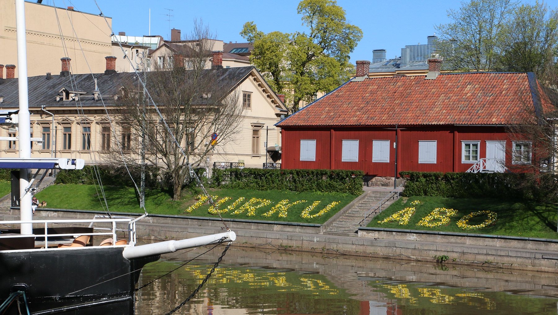 Spring flowers spell out Turku and Åbo on the banks of the Aura River.