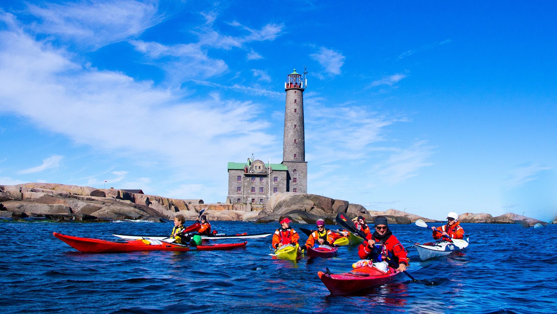 En grupp människor på ett Aavameri Open-Air Adventure paddlar sina kajaker runt Bengtskärs fyr.