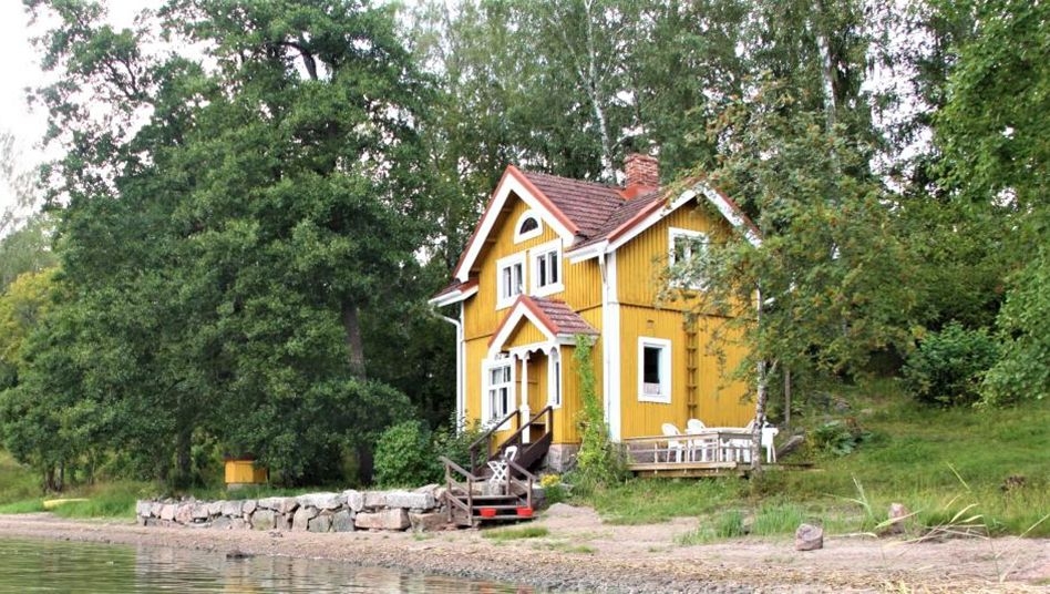 En gul stuga vid havet vid Stentorps Fårgård.