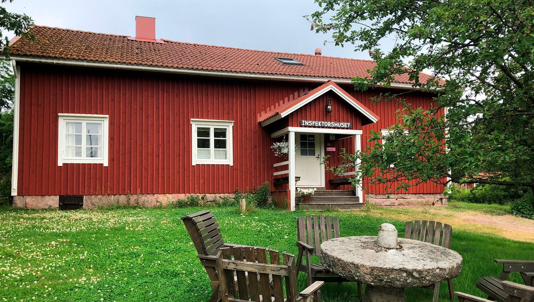 Den röda träbyggnaden på Stallbackens bed and breakfast med vita fönsterbågar.