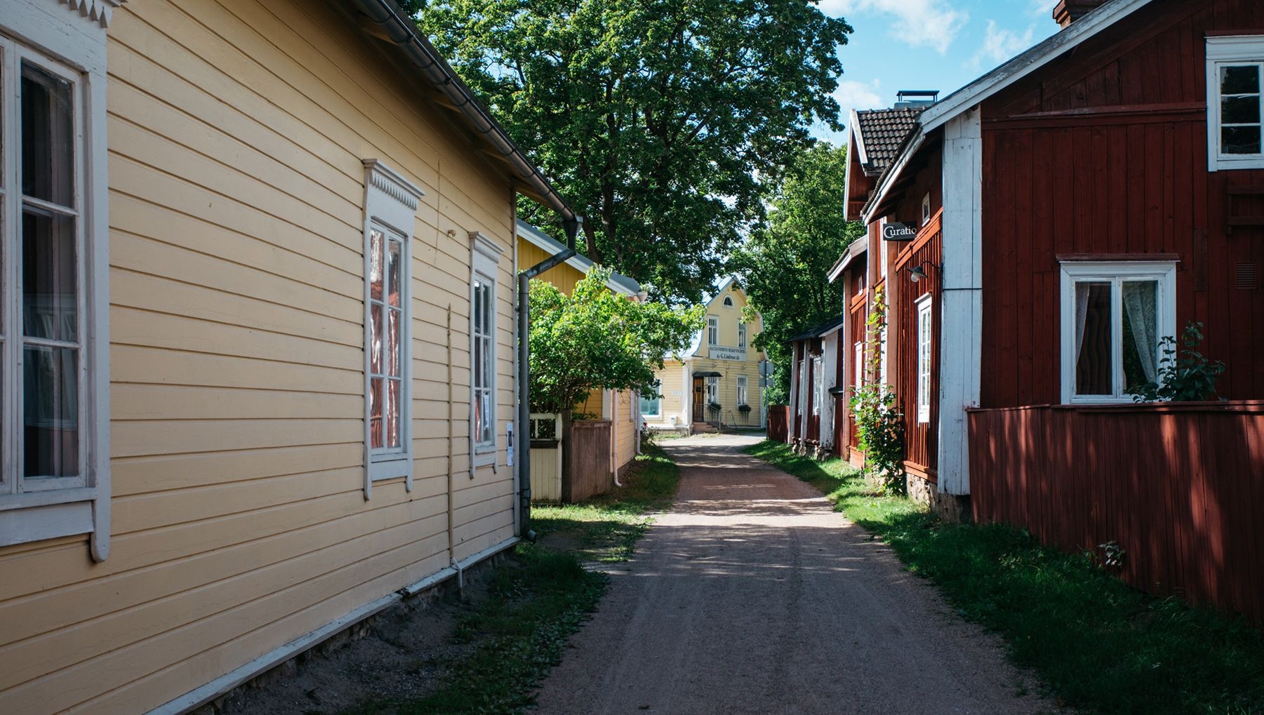 En smal gata i Pargas gamla stadsdel, kantad av trähus.