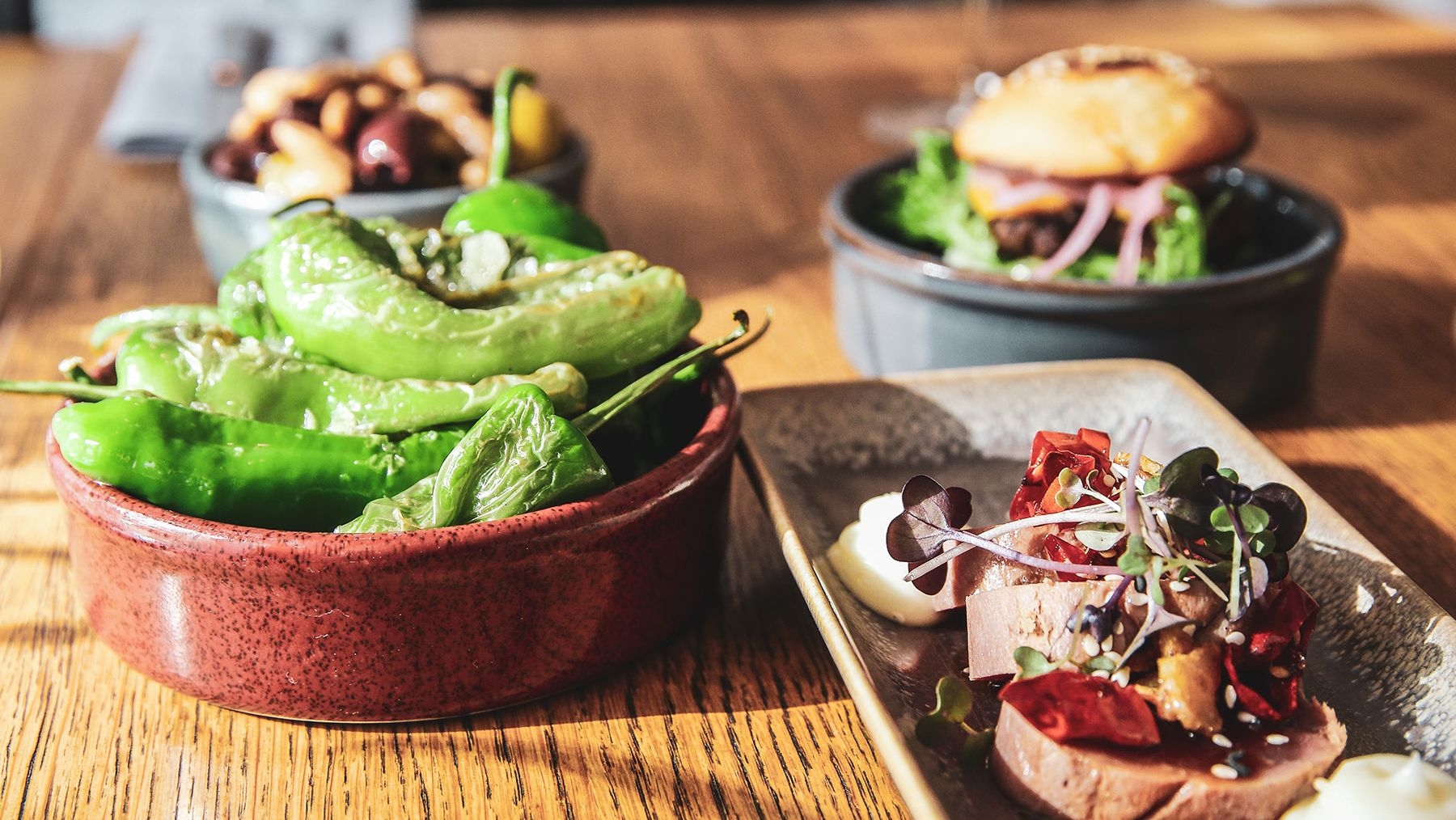 Different types of tapas, including jalapeno peppers, on a table at de Trevi.