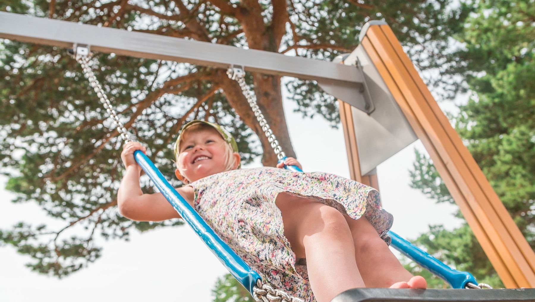 A child stands on a swing at the playground at Kasnäs.