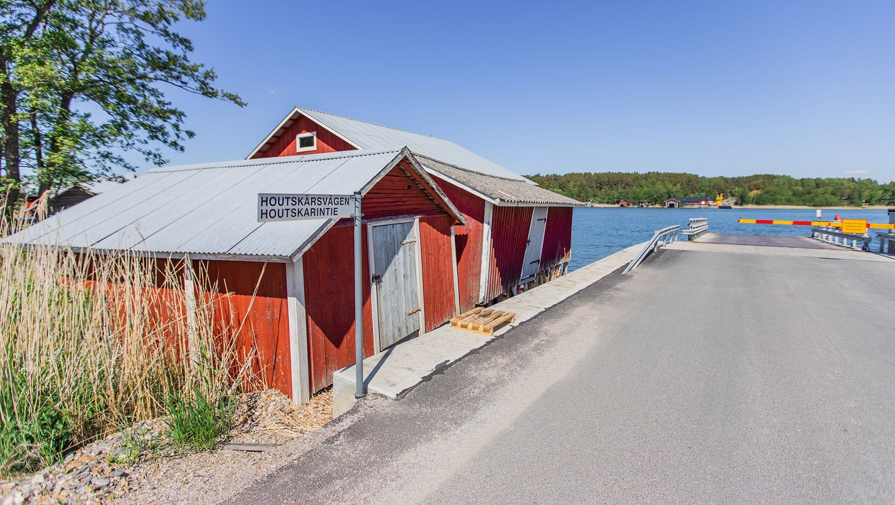 Ett färjestopp på Houtskär, bredvid en traditionell träbyggnad.