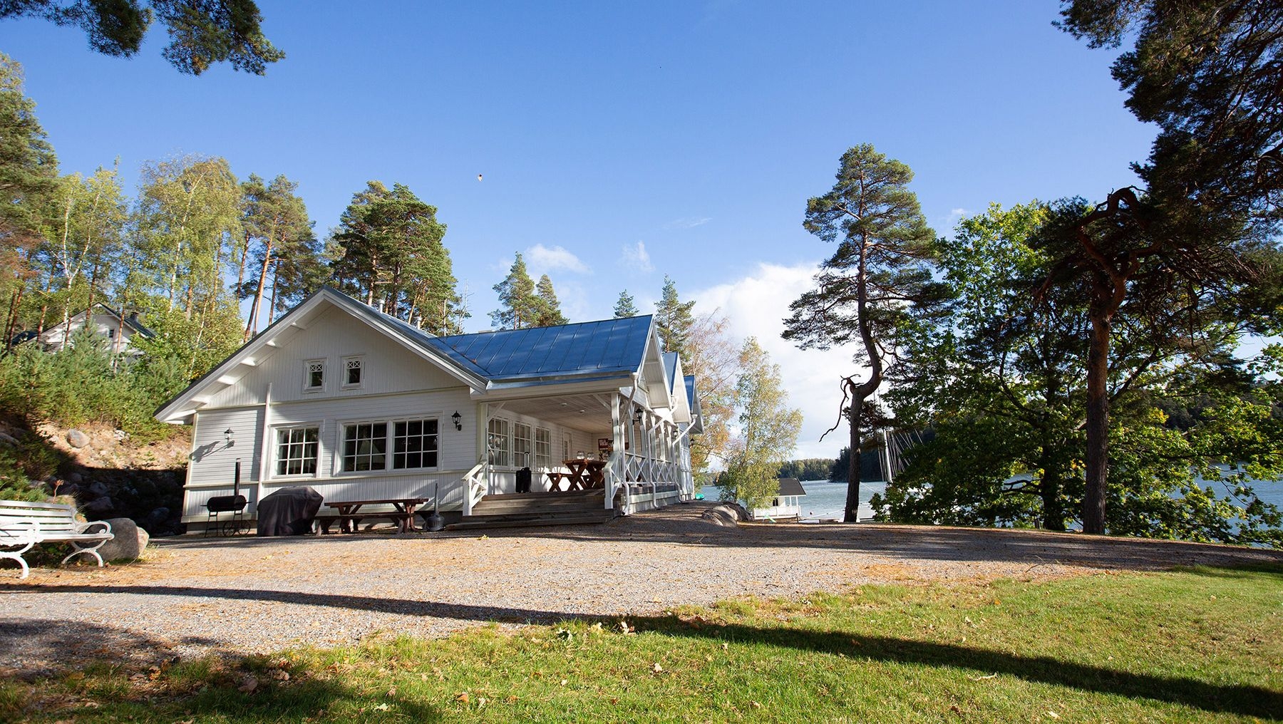 En stor vit stuga vid havet, omgiven av träd, vid Villa Wolax.