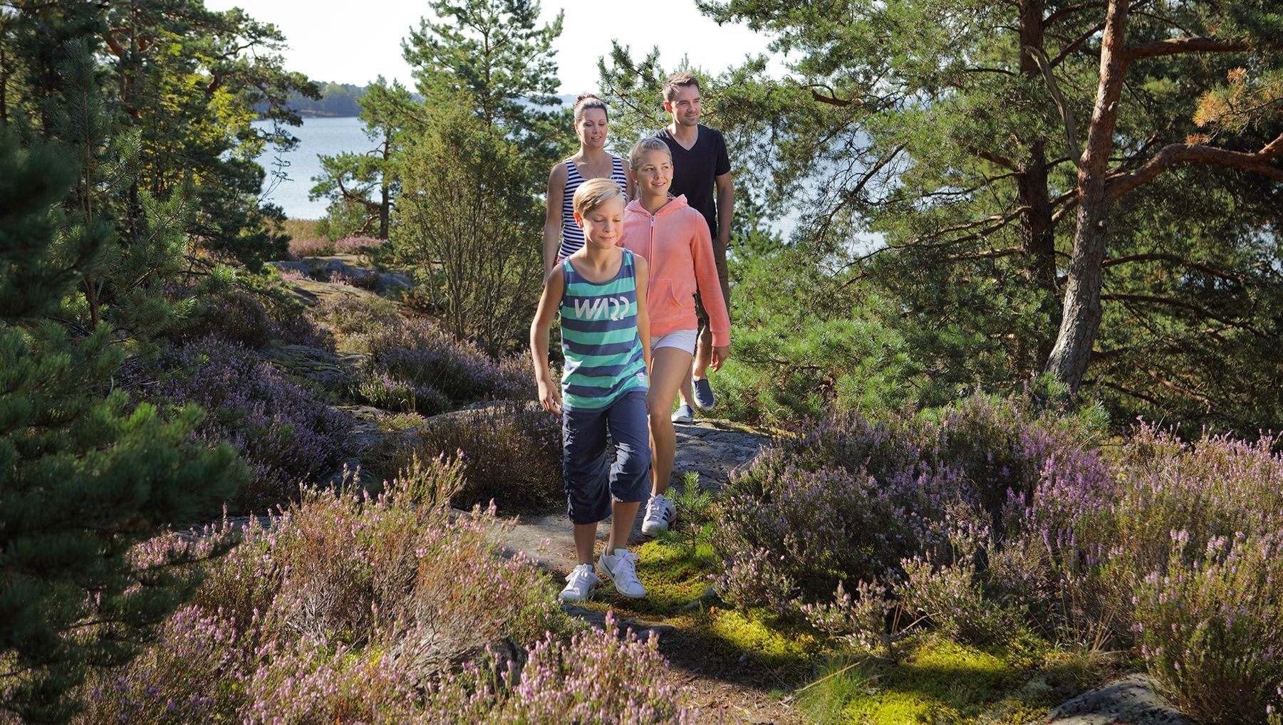 A family of four walk through the forest near Ruissalo Spa Hotel.