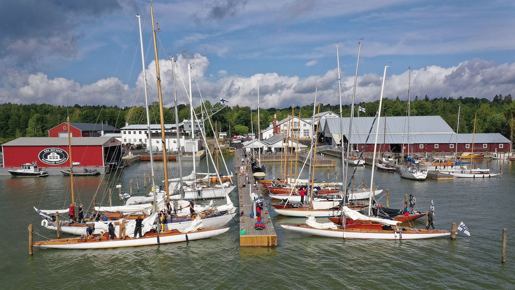 Båtar ankrade vid Ruissalo Boatyard. Det finns röda och vita byggnader i bakgrunden.