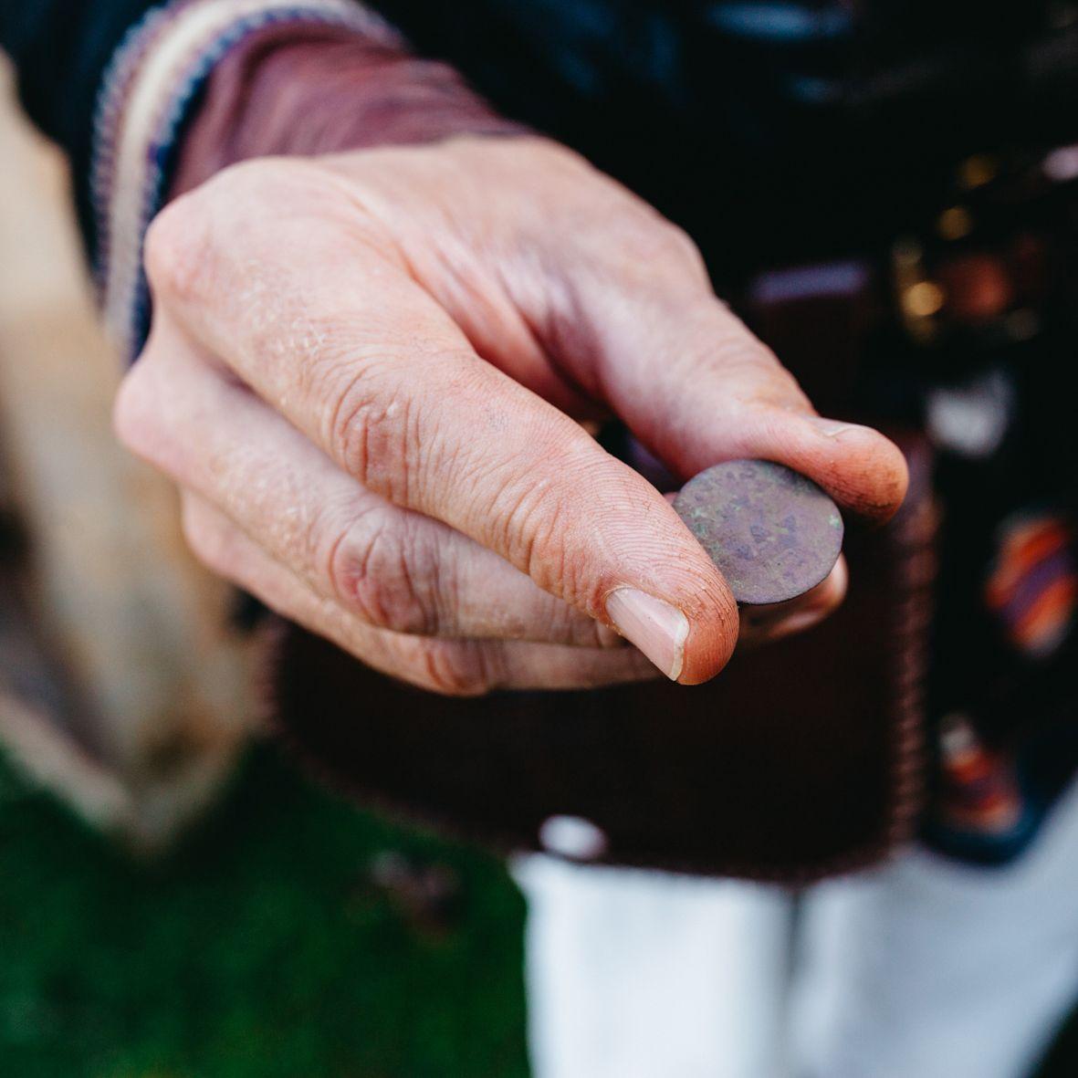 A hand holds out a coin used in Viking times at the Rosala Viking Center.