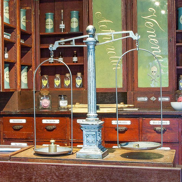 En gammal apoteksdisk på Apoteksmuseet, med en uppsättning vågar och trälådor som en gång innehöll olika typer av medicin.