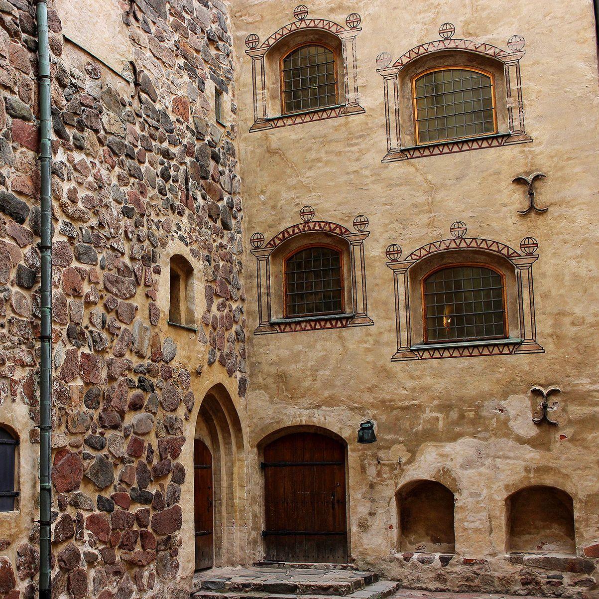 Turun linnan sisäpiha, jota ympäröivissä kiviseinissä on koristeellisia kaari-ikkunoita.