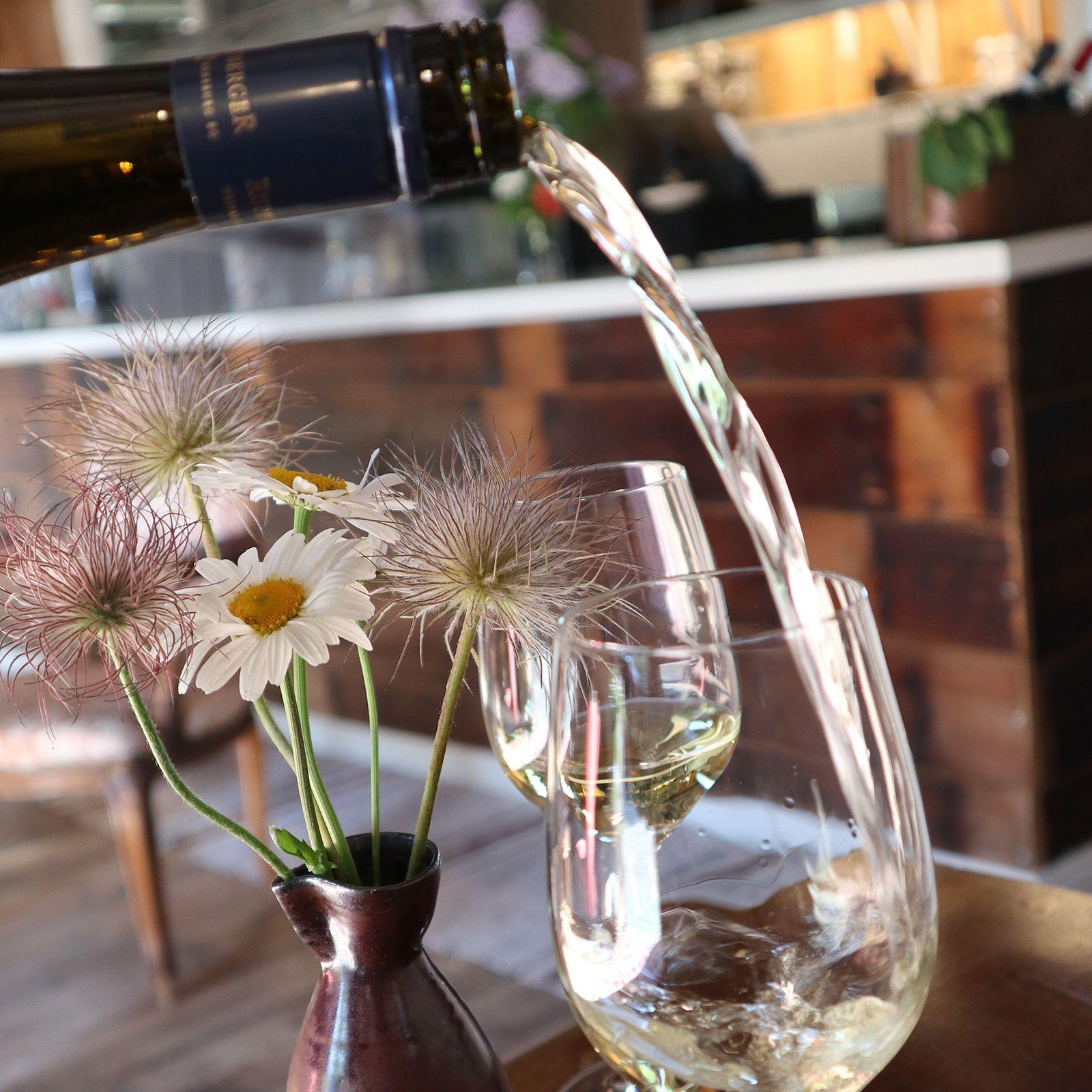 Kaksi lasillista viiniä ja kukkamaljakko pöydällä Källarvindenissä.