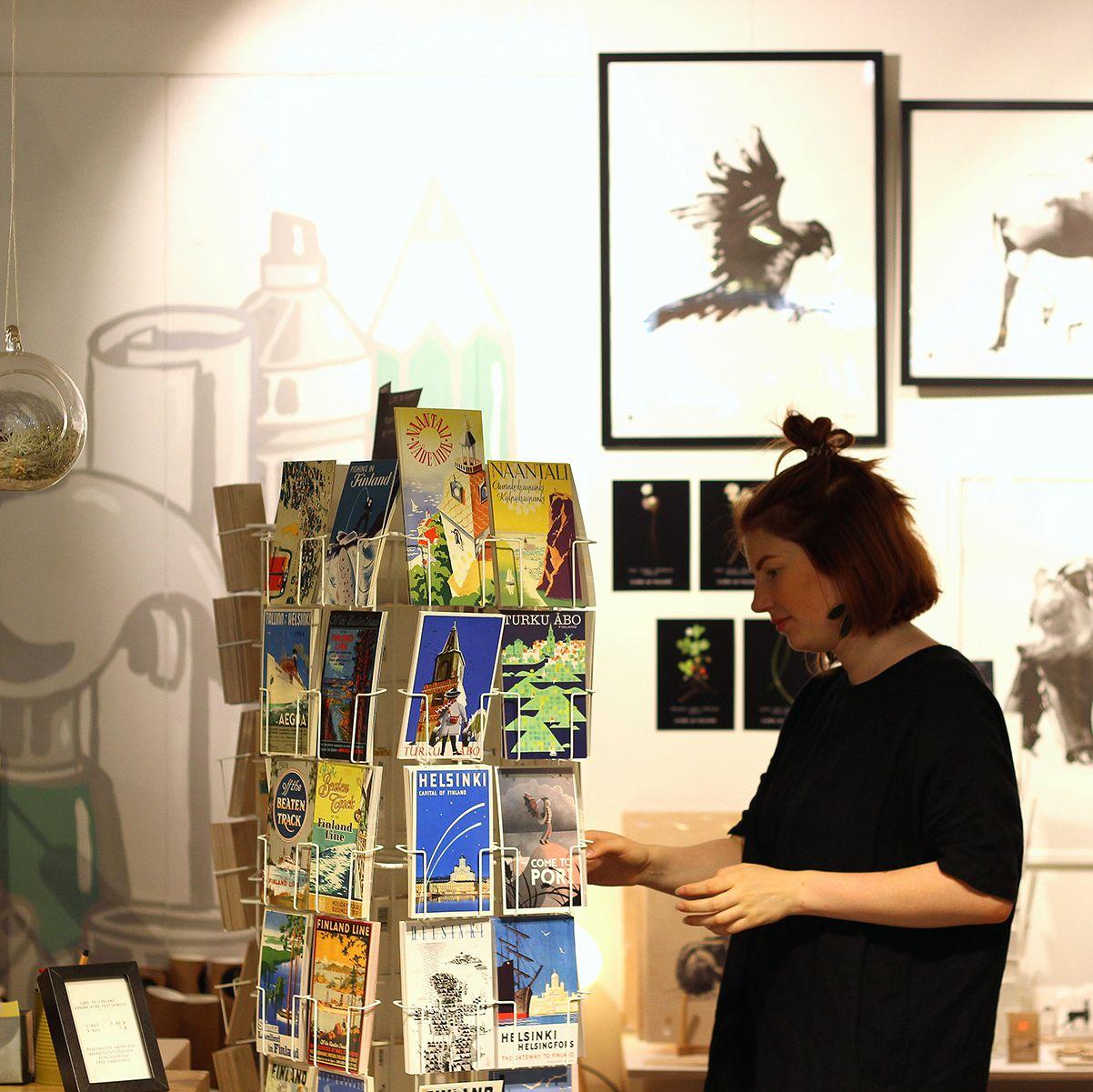 En shoppare tittar igenom vykorten som visas på PUF Design.