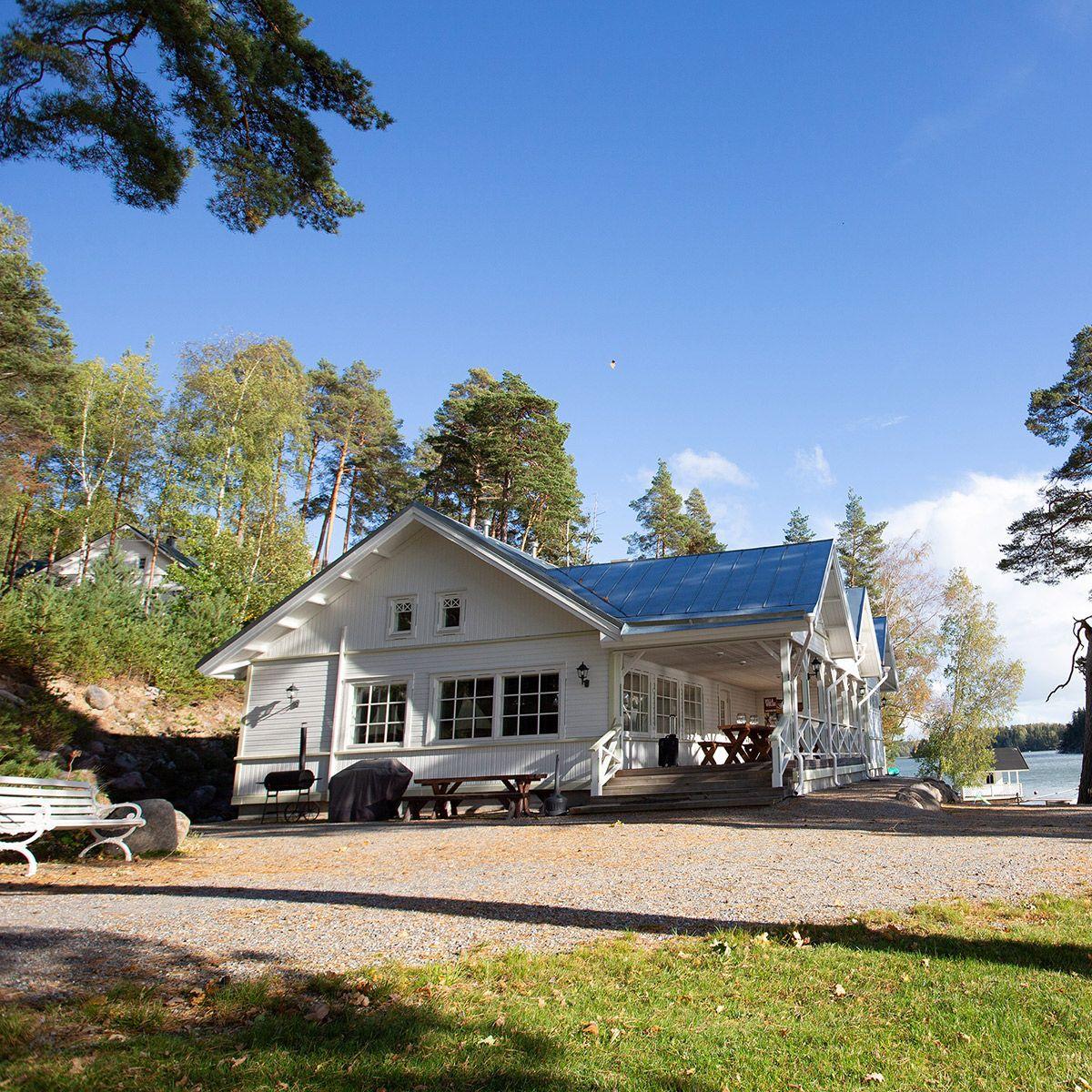 Villa Wolaxin suuri valkoinen huvila meren rannalla puiden ympäröimänä.