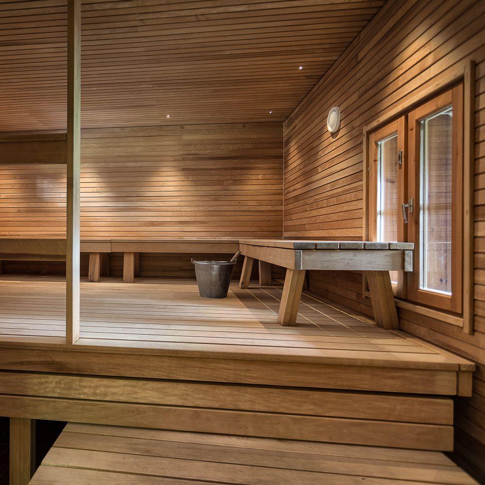 Kultarannan sauna, jossa on kaksi ikkunaa ja pitkä puupenkki seinän vieressä.