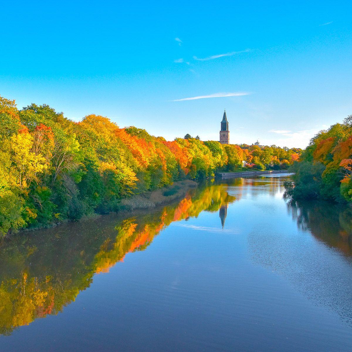 Aura River ja värikkäitä puita syksyllä. Kuvan taustalla on Turun tuomiokirkko.