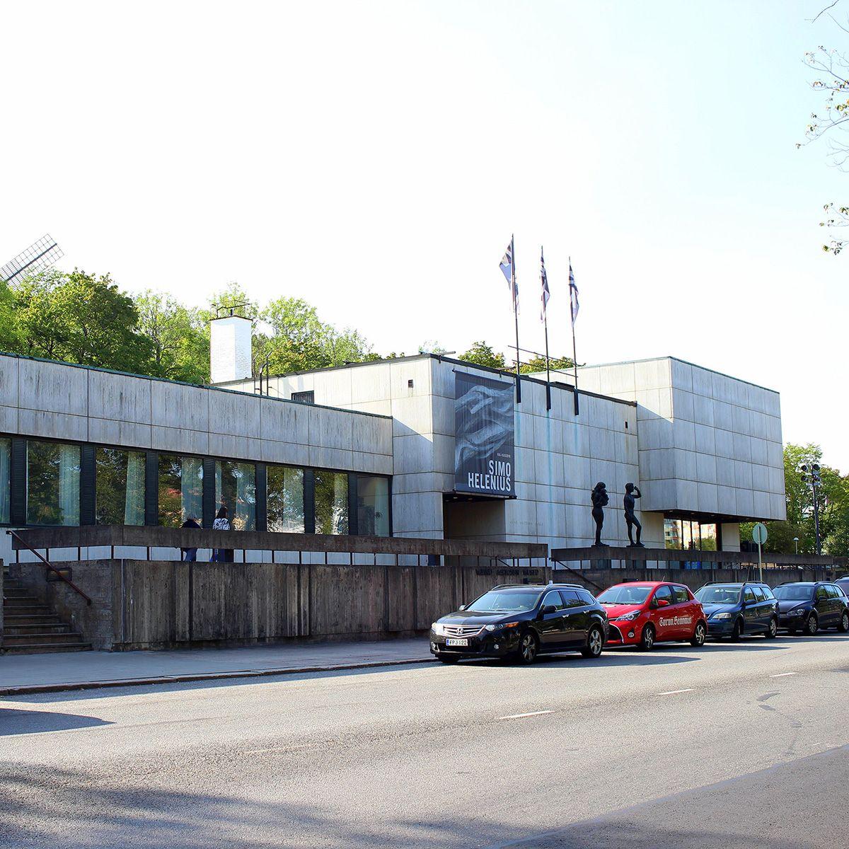 A view from the street outside Wäinö Aaltonen Museum, lined with cars and statues.