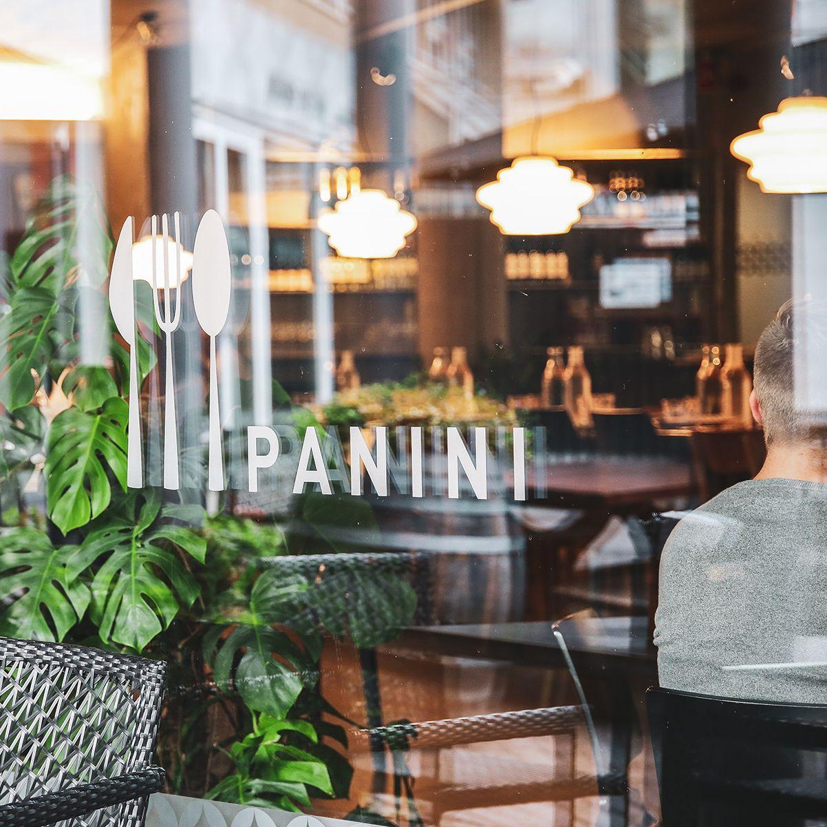 Tittar genom fönstret på Panini, som har namnet på restaurangen på glaset.