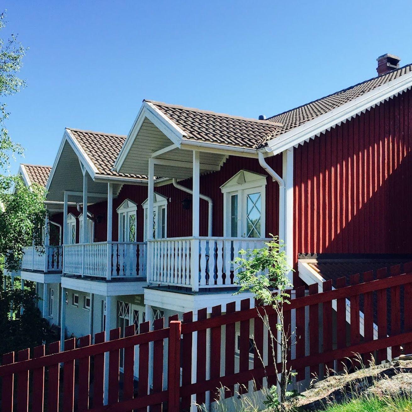 A row of red wooden cottages at Archipelago Hotel Vaihela.