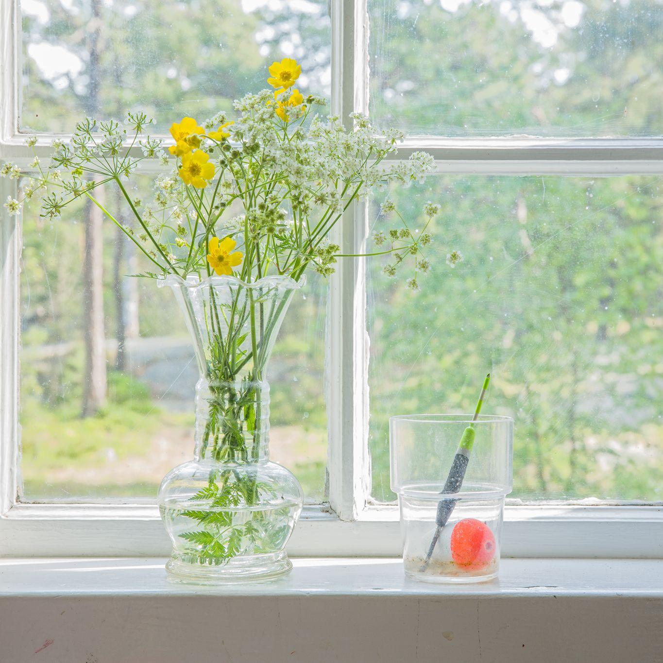 fönster med gula blommor i vas