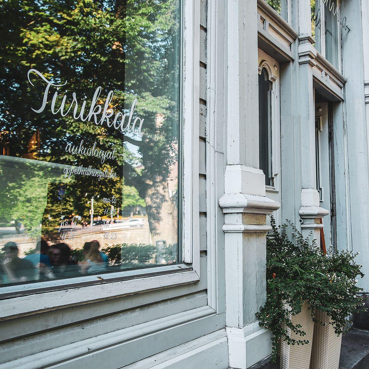 Tiirikkalas vita exteriör, med ett fönster med namnet på restaurangen i elegant manus.