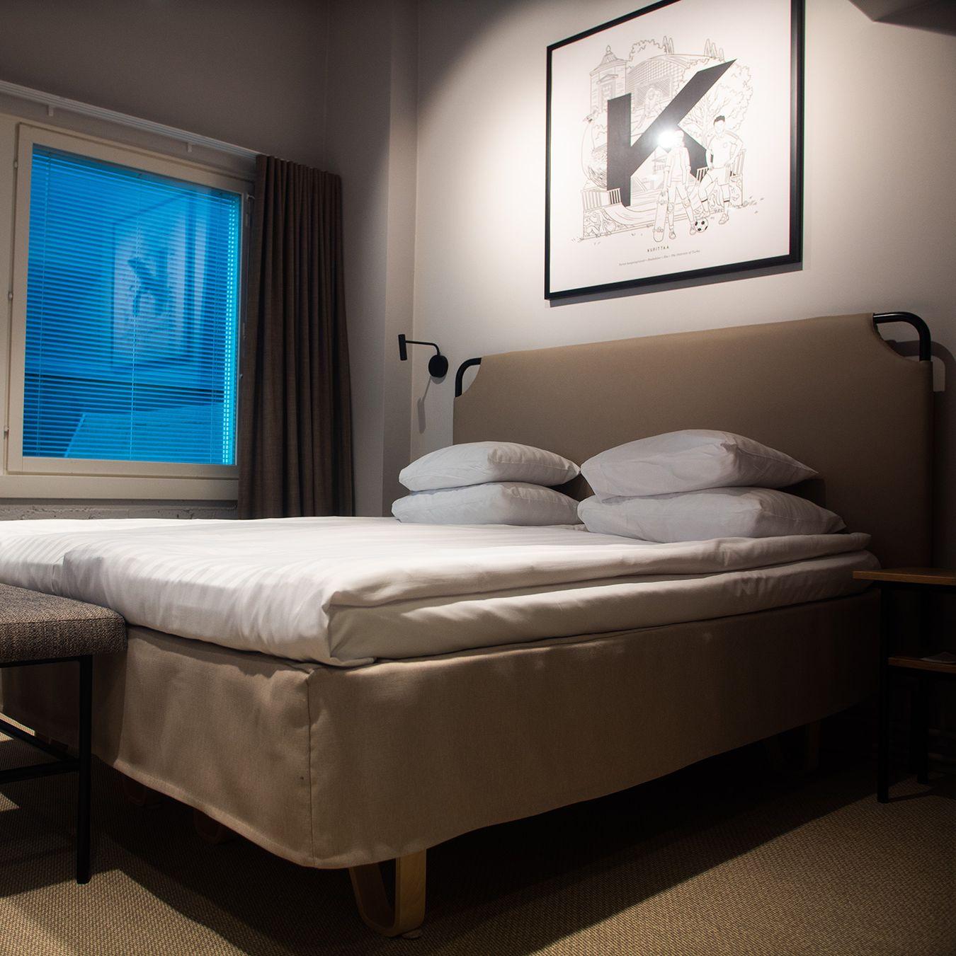 Ett modernt sovrum med dubbelsäng på Original Sokos Hotel Wiklund i Åbo.