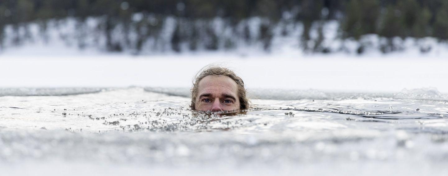 En man badar i en isvak. Henrik Trygg.