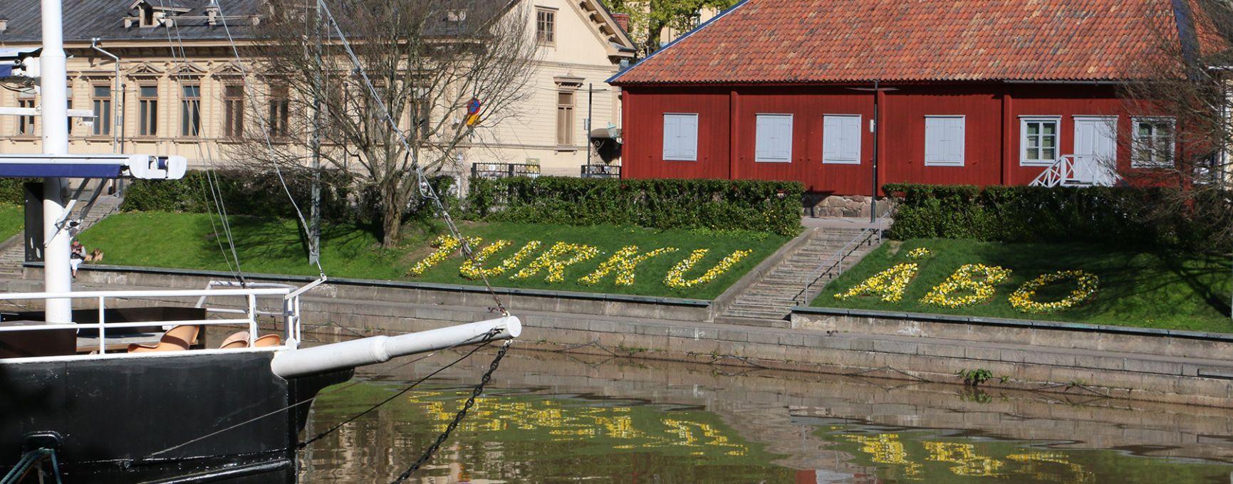 Spring flowers spell out Turku and Åbo on the banks of the Aura River.