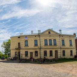 The yellow buildings of Cafe Kakola and the Kakolanmäki Hill Museum on a sunny day.