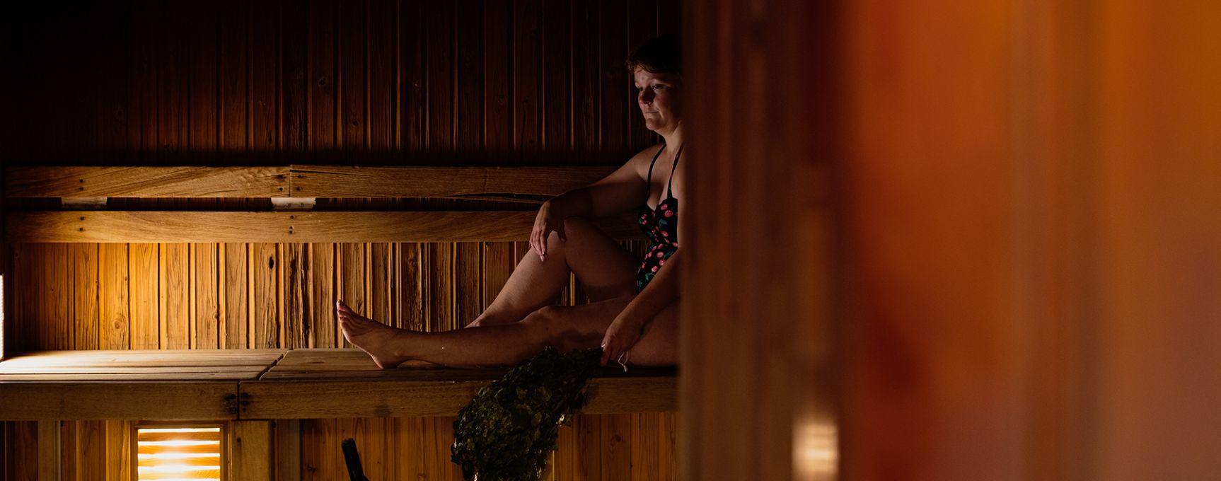 A woman sits inside a sauna on Örö Fortress Island.